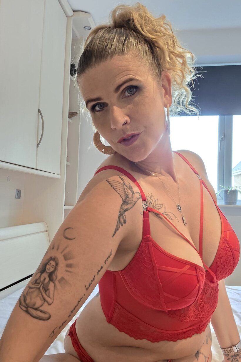 Red lingerie and a pierced lip frame this tattooed BBW solo scene, photo 7 of 10