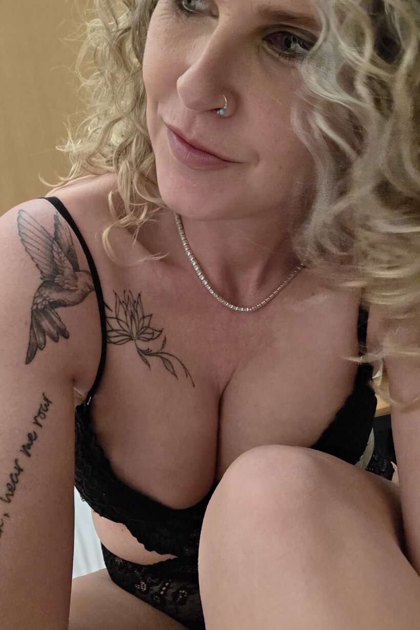 Curly-haired MILF models black lingerie while playing solo for the camera (shot 2)
