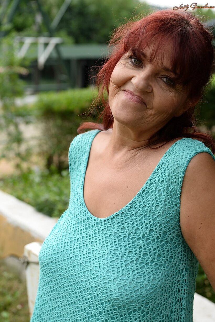 BBW nude photo 8 — Livia, a redhead granny, hikes her blue dress to show natural tits