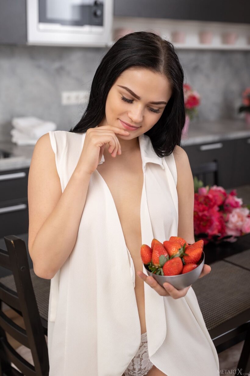 Image 1/21: Naked brunette model spreads herself on a dining table, showing tight pussy